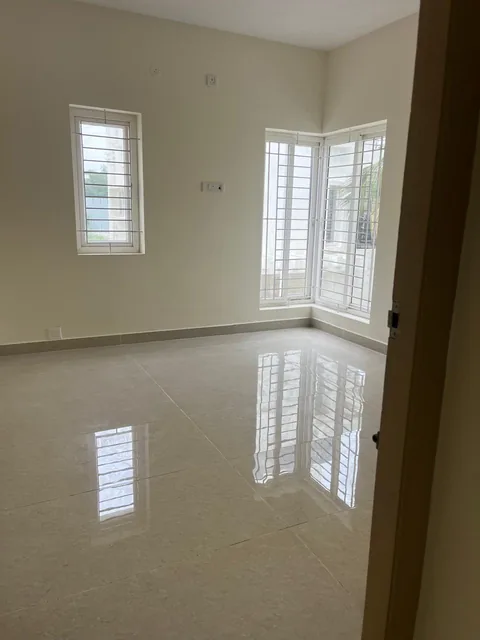 A bright bedroom with corner windows and polished flooring