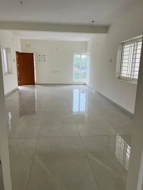 A large, naturally lit living hall with polished flooring