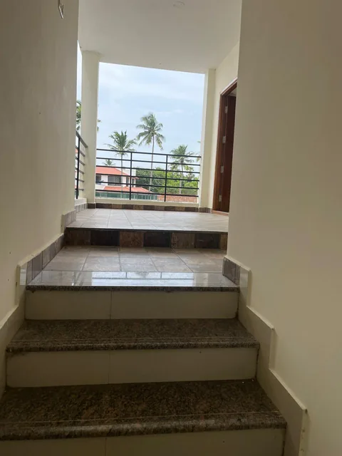 The staircase rising to a naturally lit upper-floor foyer